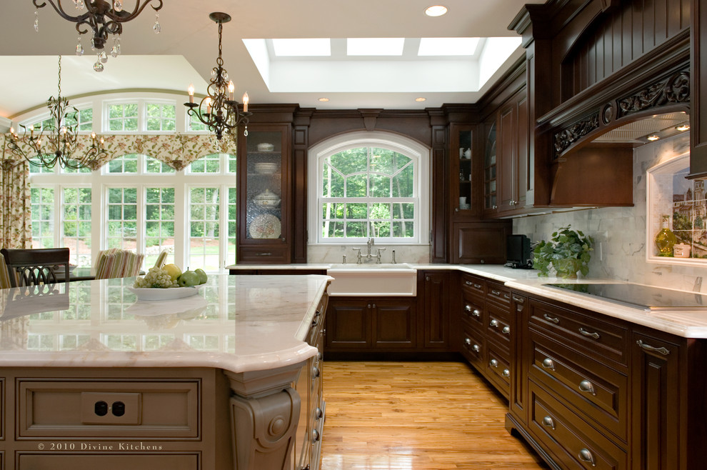 Example of a large classic l-shaped dark wood floor eat-in kitchen design in Boston with a farmhouse sink, raised-panel cabinets, dark wood cabinets, marble countertops, white backsplash, stone tile backsplash, stainless steel appliances and an island