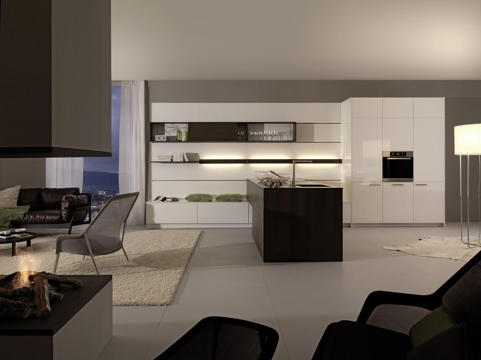 Стильный дизайн: угловая кухня-гостиная в стиле модернизм с плоскими фасадами, техникой из нержавеющей стали и черно-белыми фасадами - последний тренд
