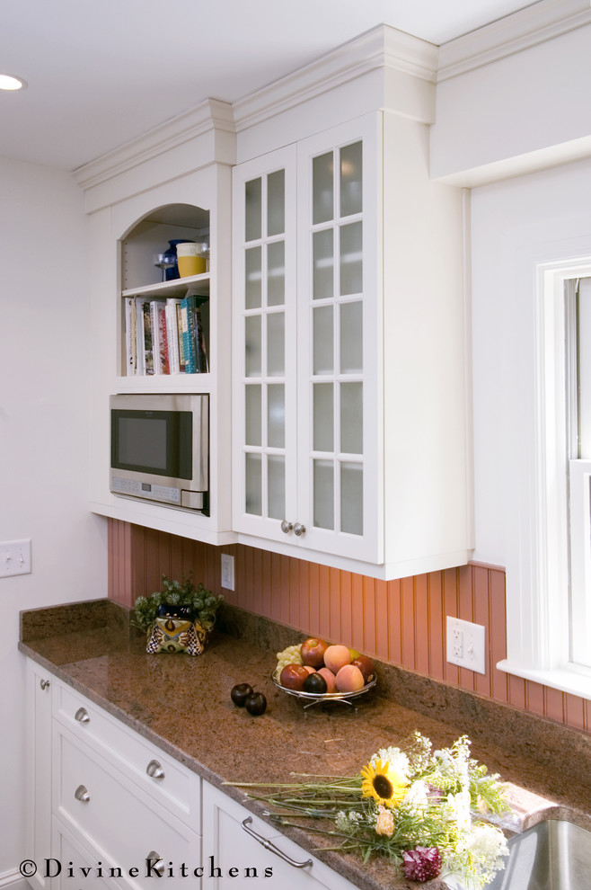 Foto på ett litet vintage kök, med en undermonterad diskho, luckor med profilerade fronter, vita skåp, granitbänkskiva, rött stänkskydd, stänkskydd i keramik, rostfria vitvaror och mörkt trägolv