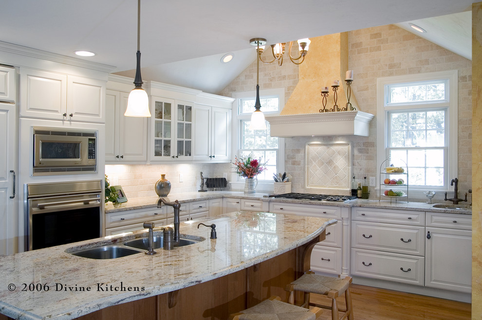 Inspiration for a large traditional l-shaped kitchen/diner in Boston with a double-bowl sink, raised-panel cabinets, white cabinets, granite worktops, beige splashback, stone tiled splashback, stainless steel appliances, medium hardwood flooring and an island.