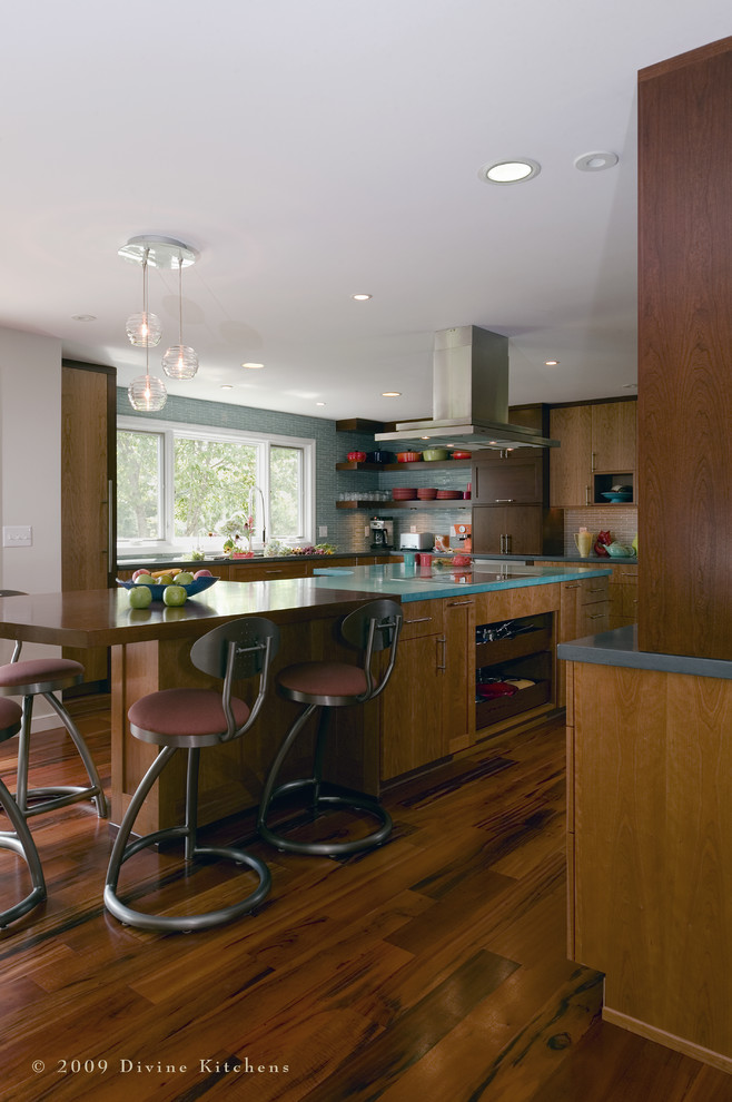 Example of a huge trendy u-shaped dark wood floor eat-in kitchen design in Boston with an undermount sink, flat-panel cabinets, dark wood cabinets, concrete countertops, blue backsplash, glass tile backsplash, stainless steel appliances and an island