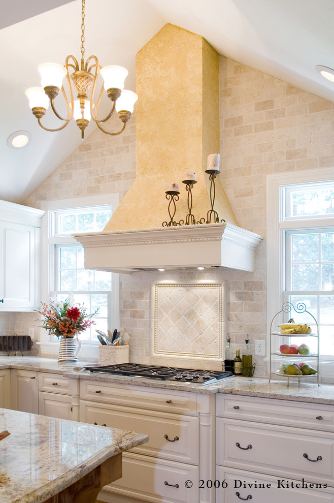 Klassisk inredning av ett stort kök, med en dubbel diskho, luckor med upphöjd panel, vita skåp, granitbänkskiva, beige stänkskydd, stänkskydd i stenkakel, rostfria vitvaror, mellanmörkt trägolv och en köksö