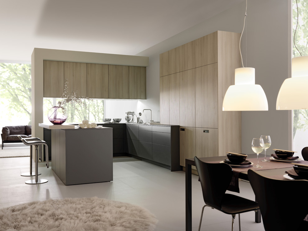 На фото: угловая кухня в стиле модернизм с обеденным столом, плоскими фасадами, светлыми деревянными фасадами, барной стойкой и двухцветным гарнитуром с