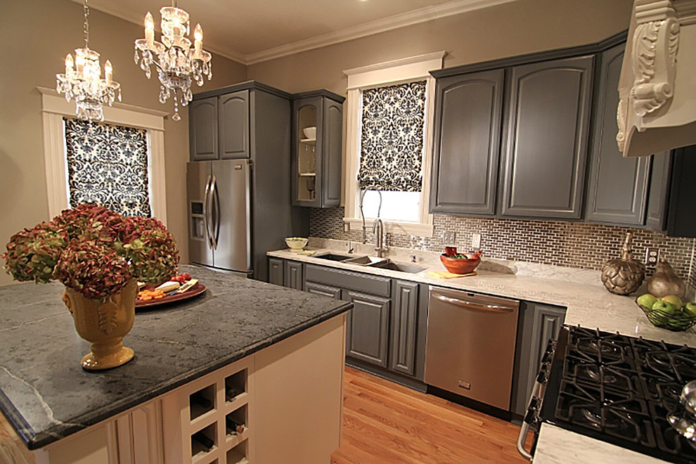 Bild på ett vintage kök, med en undermonterad diskho, luckor med upphöjd panel, grå skåp, marmorbänkskiva, orange stänkskydd, stänkskydd i glaskakel, rostfria vitvaror, ljust trägolv och en köksö