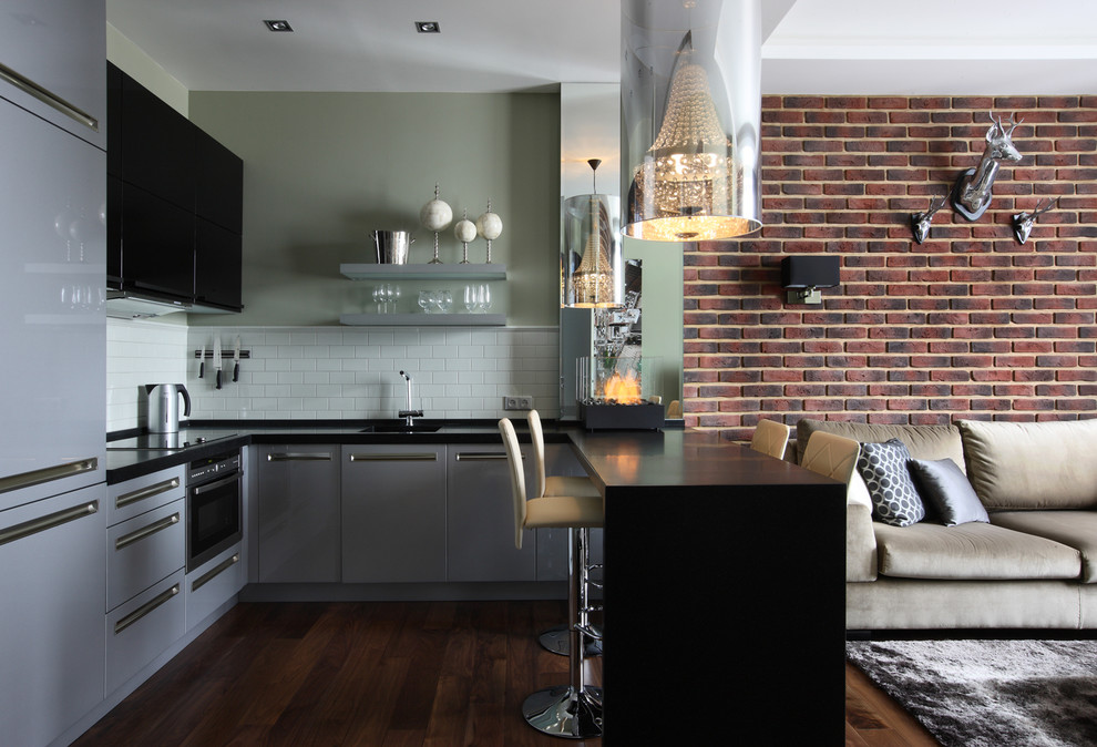 Photo of a contemporary u-shaped open plan kitchen in Moscow with flat-panel cabinets, grey cabinets, white splashback, stainless steel appliances, dark hardwood flooring, a breakfast bar and metro tiled splashback.