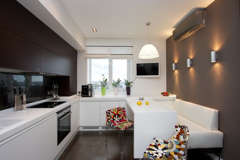 Trendy l-shaped eat-in kitchen photo with an undermount sink, flat-panel cabinets, dark wood cabinets, black backsplash and glass sheet backsplash
