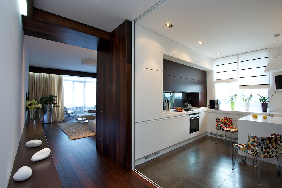 This is an example of a contemporary kitchen with flat-panel cabinets, white cabinets and stainless steel appliances.