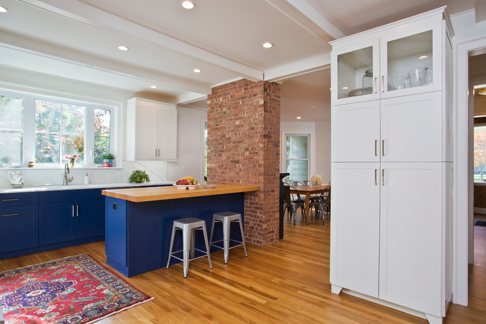 Foto de cocinas en L contemporánea de tamaño medio con armarios estilo shaker, puertas de armario azules, encimera de cuarcita y una isla