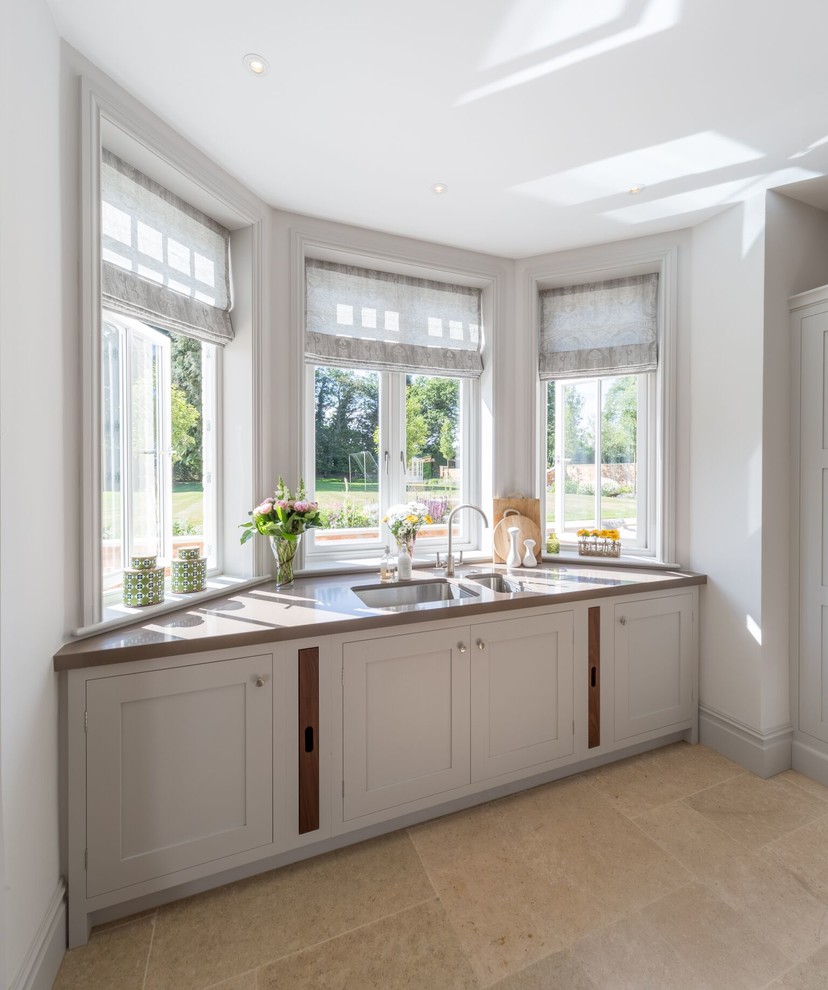 Example of a country l-shaped kitchen design in Oxfordshire with shaker cabinets, gray cabinets, blue backsplash and an island