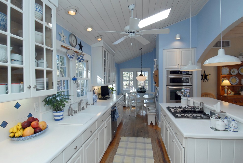 Idéer för att renovera ett eklektiskt kök, med en dubbel diskho, luckor med glaspanel, vita skåp, flerfärgad stänkskydd och rostfria vitvaror
