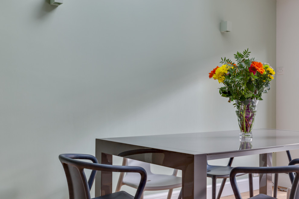 Réalisation d'une salle à manger ouverte sur la cuisine design de taille moyenne avec un sol en bois brun et un plafond voûté.