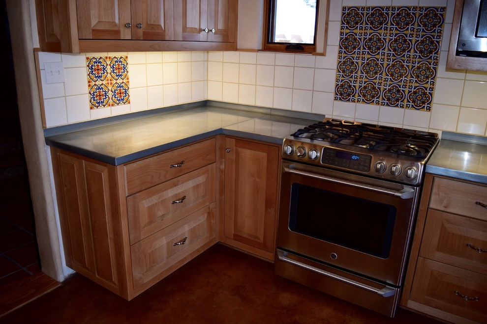 Foto på ett mellanstort eklektiskt kök, med luckor med upphöjd panel, skåp i mellenmörkt trä, vitt stänkskydd, stänkskydd i keramik, rostfria vitvaror och betonggolv