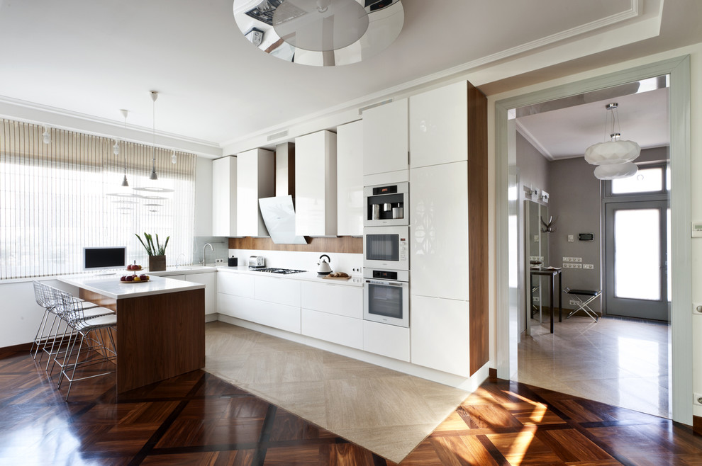 Moderne Wohnküche in U-Form mit flächenbündigen Schrankfronten, weißen Schränken, Küchenrückwand in Weiß, weißen Elektrogeräten und Halbinsel in Moskau
