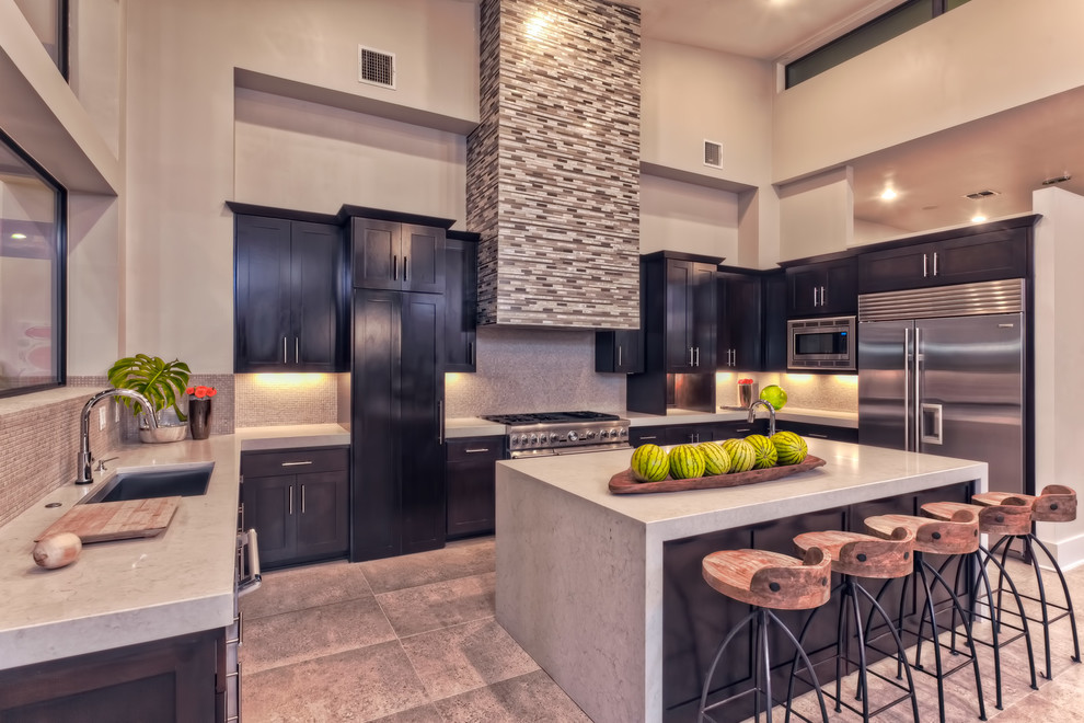 Example of a mid-sized trendy u-shaped porcelain tile open concept kitchen design in Austin with an undermount sink, shaker cabinets, dark wood cabinets, quartz countertops, gray backsplash, stainless steel appliances and an island