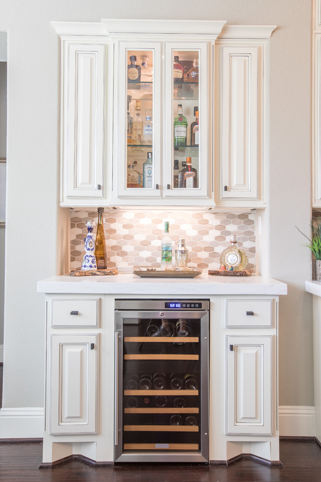 Design ideas for a traditional home bar in Houston with white cabinets, engineered stone countertops, multi-coloured splashback, mosaic tiled splashback and dark hardwood flooring.