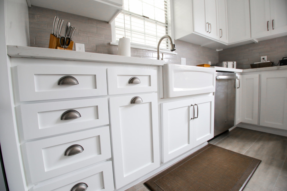 Exempel på ett mellanstort klassiskt vit vitt kök, med en undermonterad diskho, skåp i shakerstil, vita skåp, bänkskiva i kvartsit, grått stänkskydd, stänkskydd i tunnelbanekakel, rostfria vitvaror, ljust trägolv och grått golv
