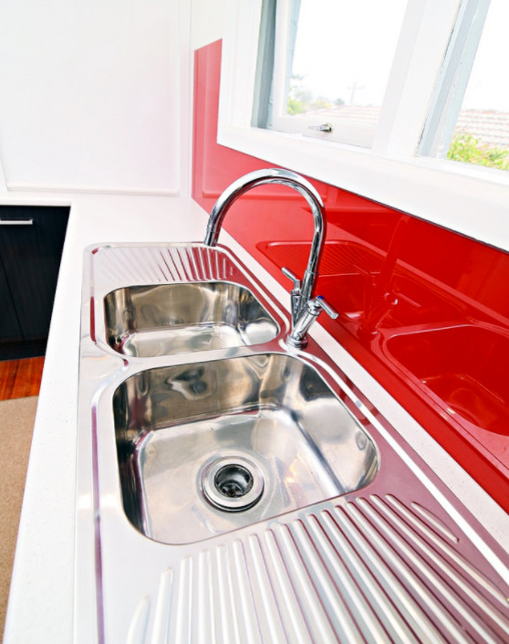 Immagine di una cucina design di medie dimensioni con lavello a doppia vasca, ante lisce, ante bianche, top in laminato, paraspruzzi rosso, paraspruzzi con lastra di vetro, elettrodomestici in acciaio inossidabile e nessuna isola