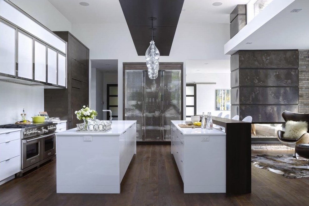 Inspiration for a medium sized contemporary single-wall kitchen in Toronto with a submerged sink, flat-panel cabinets, white cabinets, white splashback, stainless steel appliances, medium hardwood flooring and multiple islands.