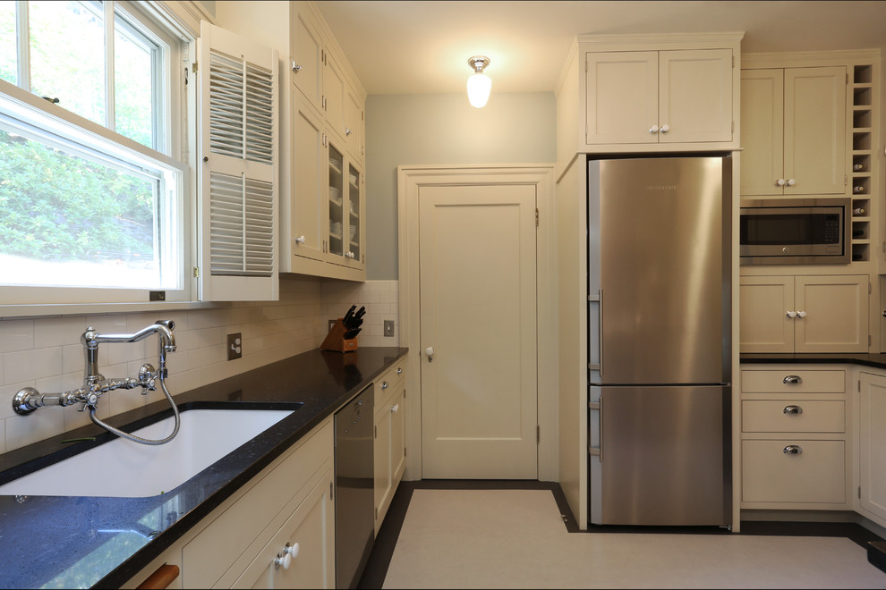 ポートランドにある高級な小さなトラディショナルスタイルのおしゃれなキッチン (アンダーカウンターシンク、落し込みパネル扉のキャビネット、白いキャビネット、クオーツストーンカウンター、白いキッチンパネル、サブウェイタイルのキッチンパネル、シルバーの調理設備、リノリウムの床、アイランドなし) の写真
