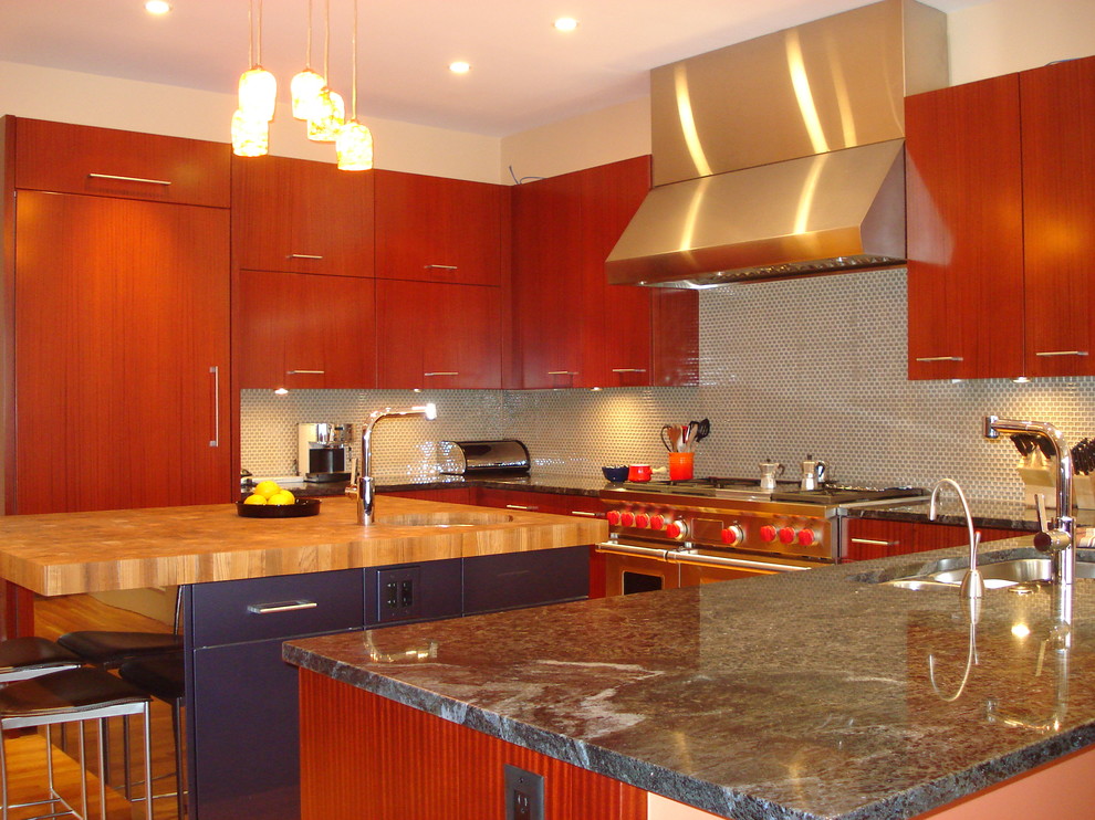 Immagine di una cucina design con elettrodomestici da incasso, top in marmo, ante lisce e ante in legno bruno