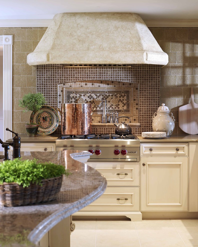 Idee per una cucina chic con elettrodomestici in acciaio inossidabile, ante beige, paraspruzzi marrone, paraspruzzi con piastrelle a mosaico e ante con riquadro incassato