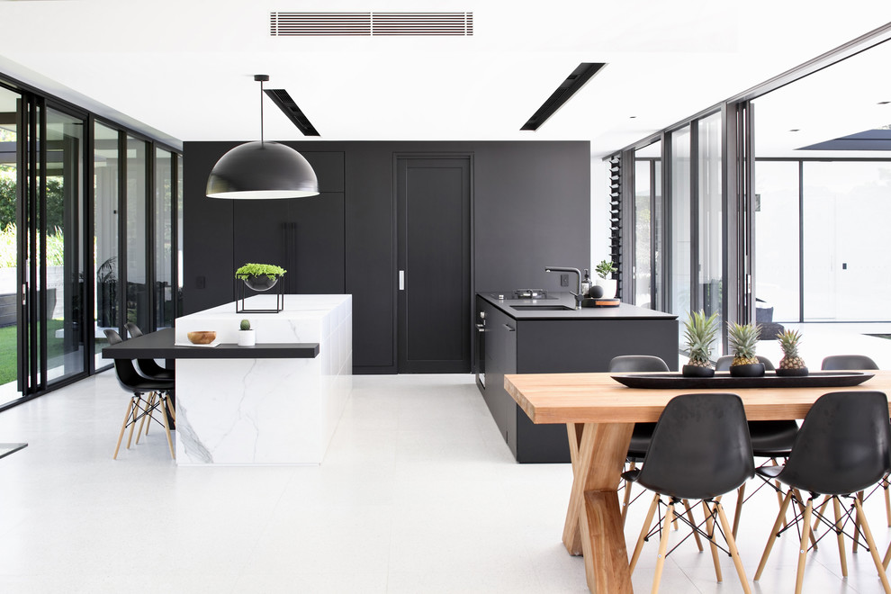 Idee per una cucina design con lavello sottopiano, ante lisce, ante nere, paraspruzzi nero, 2 o più isole, pavimento bianco e top bianco