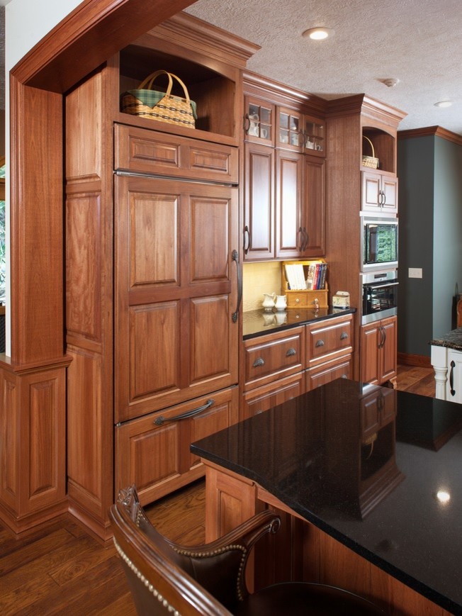 Kitchen - traditional galley kitchen idea in Other with raised-panel cabinets, granite countertops, paneled appliances and an island