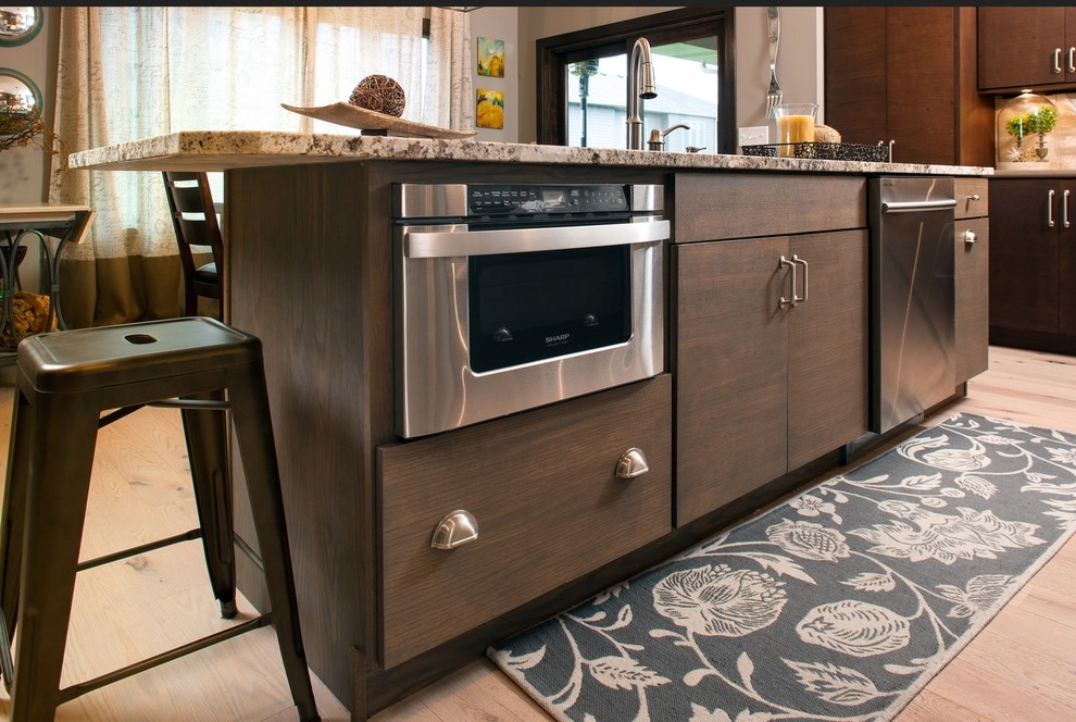 Imagen de cocinas en L bohemia con armarios con paneles lisos, electrodomésticos de acero inoxidable y una isla