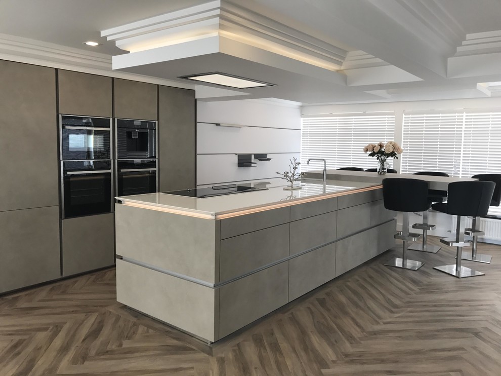 Imagen de cocina lineal contemporánea de tamaño medio con península, armarios con paneles lisos, puertas de armario grises y suelo gris