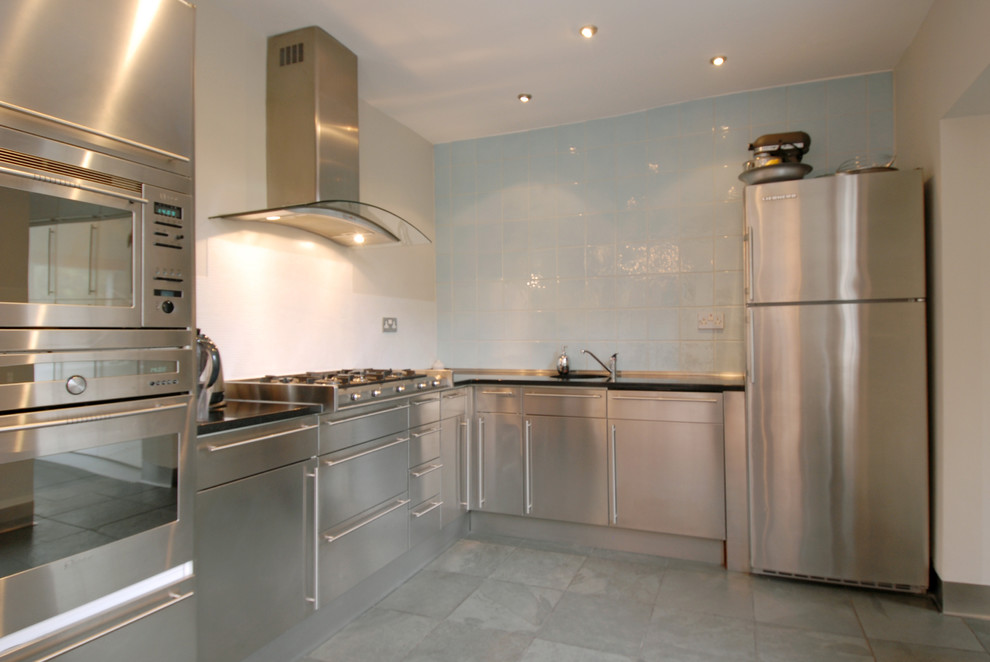 Immagine di una piccola cucina industriale con lavello sottopiano, paraspruzzi blu, paraspruzzi con piastrelle in ceramica, elettrodomestici in acciaio inossidabile e pavimento in ardesia