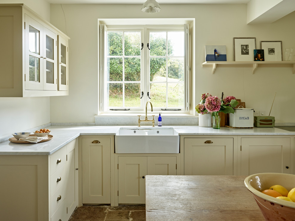 Medium sized country l-shaped open plan kitchen in Dorset with a belfast sink, shaker cabinets, yellow cabinets, marble worktops, grey splashback, marble splashback, integrated appliances, limestone flooring, an island, grey floors and grey worktops.