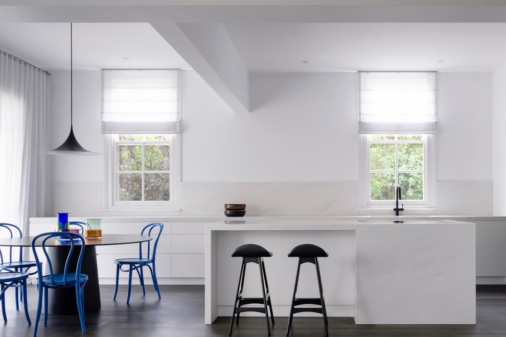 Zweizeilige Moderne Wohnküche mit Unterbauwaschbecken, flächenbündigen Schrankfronten, Küchenrückwand in Beige, Elektrogeräten mit Frontblende, dunklem Holzboden, Kücheninsel, braunem Boden und weißer Arbeitsplatte in Sydney