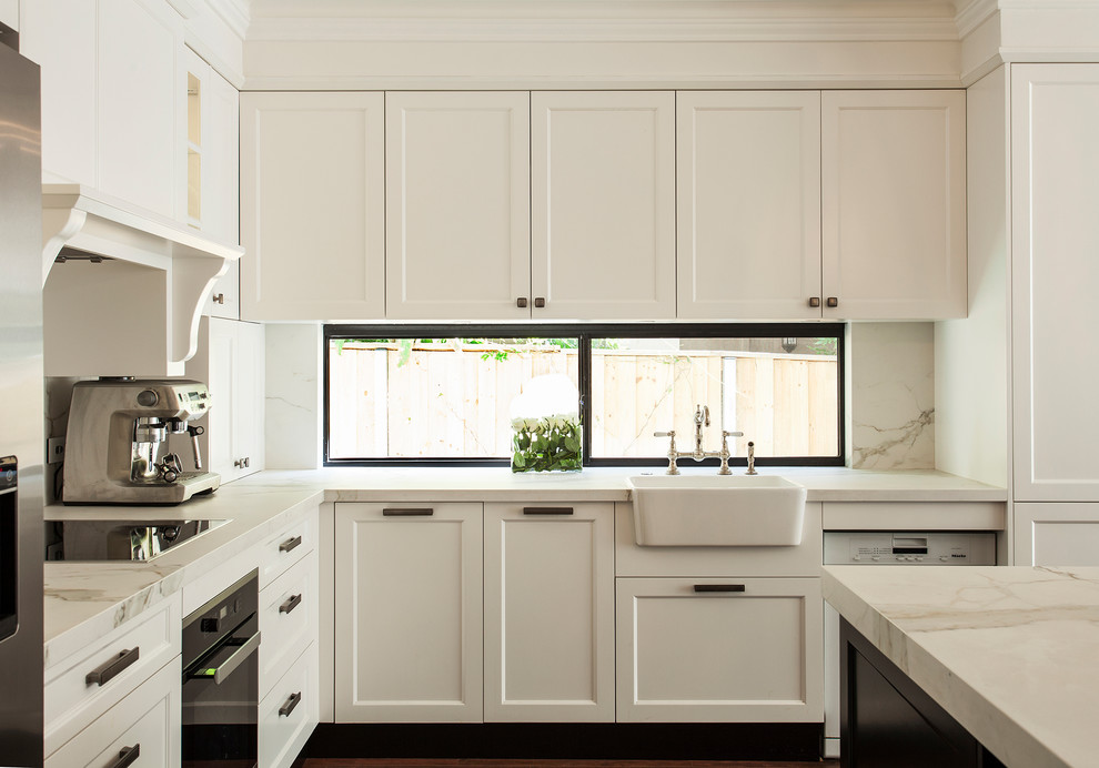 Landhaus Küche mit Landhausspüle, Schrankfronten im Shaker-Stil, weißen Schränken, Küchenrückwand in Weiß, Rückwand-Fenster und schwarzen Elektrogeräten in Sydney