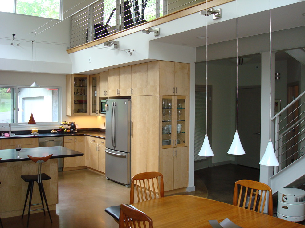 Mid-Century Küche in U-Form mit Glasfronten, hellen Holzschränken, Granit-Arbeitsplatte, Küchenrückwand in Schwarz, Küchengeräten aus Edelstahl, Betonboden und Halbinsel in New York