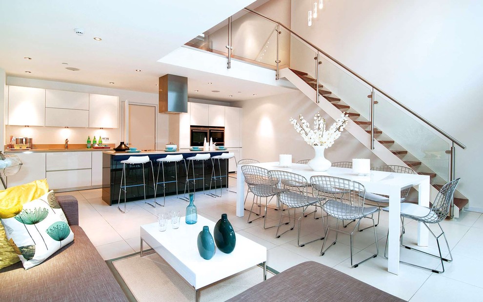Photo of an expansive modern open plan kitchen in London with flat-panel cabinets, white cabinets, granite worktops, stainless steel appliances, porcelain flooring and an island.