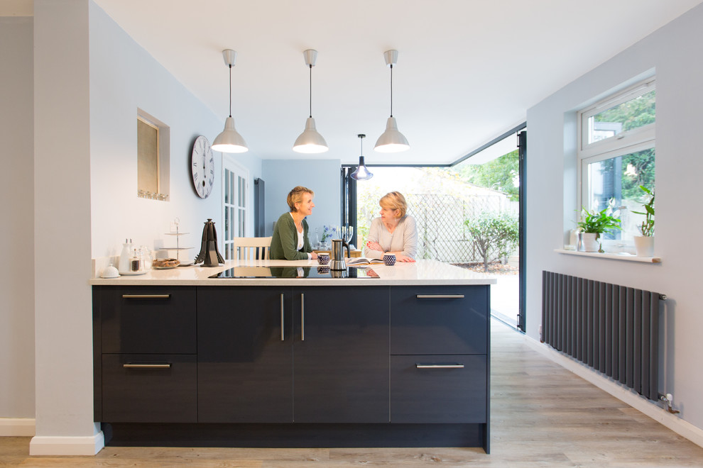 Design ideas for a medium sized contemporary u-shaped open plan kitchen in Surrey with flat-panel cabinets, grey cabinets, quartz worktops and an island.