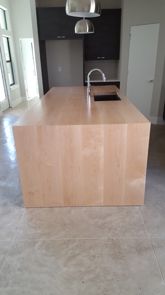 Esempio di una grande cucina minimal con ante lisce, top in legno, elettrodomestici in acciaio inossidabile e pavimento in cemento