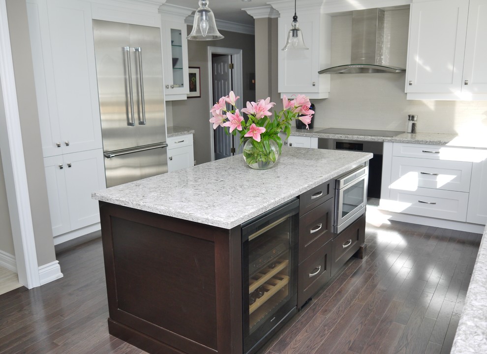 Eat-in kitchen - large transitional l-shaped dark wood floor eat-in kitchen idea in Toronto with an undermount sink, shaker cabinets, white cabinets, quartz countertops, beige backsplash, porcelain backsplash, stainless steel appliances and an island