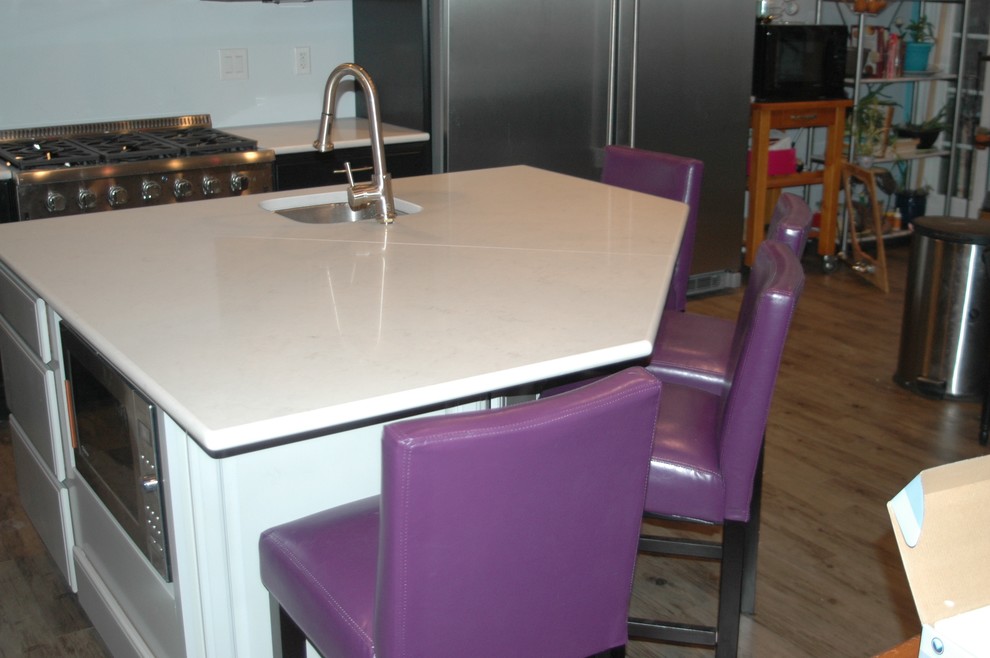 Пример оригинального дизайна: угловая кухня среднего размера в современном стиле с обеденным столом, столешницей из кварцевого агломерата, техникой из нержавеющей стали и островом