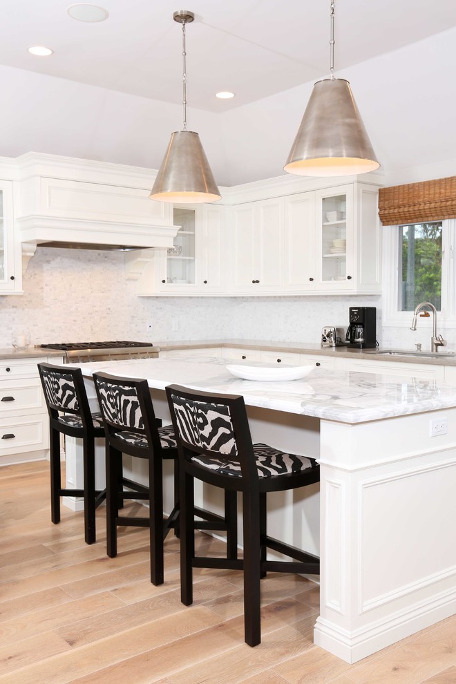 Design ideas for a kitchen in Orange County with light hardwood flooring and an island.