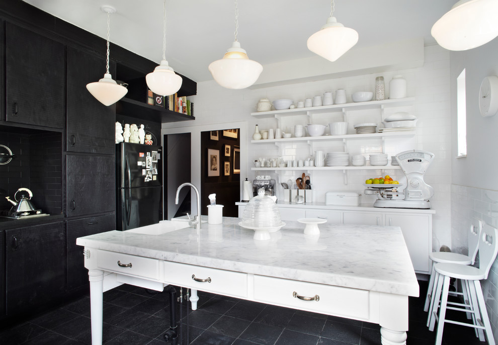 Diseño de cocina contemporánea con salpicadero de azulejos tipo metro, electrodomésticos negros, encimera de mármol, armarios con paneles lisos, salpicadero blanco y con blanco y negro