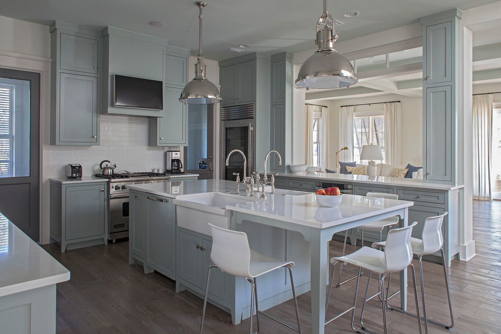 Beach style u-shaped light wood floor open concept kitchen photo in Miami with a farmhouse sink, recessed-panel cabinets, blue cabinets, white backsplash, subway tile backsplash and stainless steel appliances