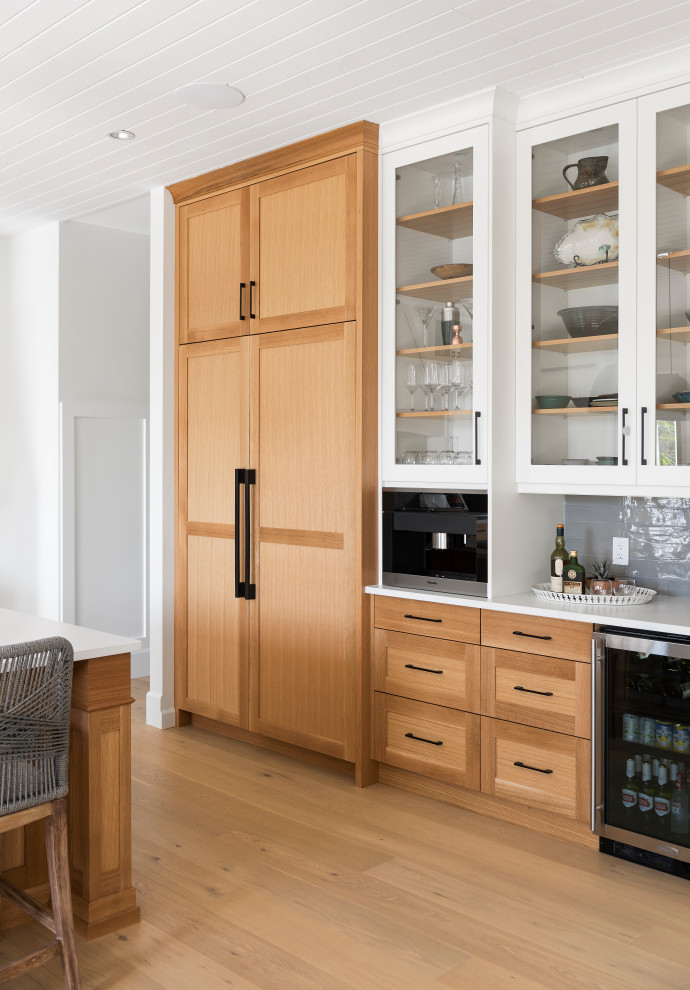 Bild på ett litet brun brunt kök och matrum, med en rustik diskho, skåp i shakerstil, vita skåp, träbänkskiva, grått stänkskydd, stänkskydd i tunnelbanekakel, svarta vitvaror, en köksö och brunt golv