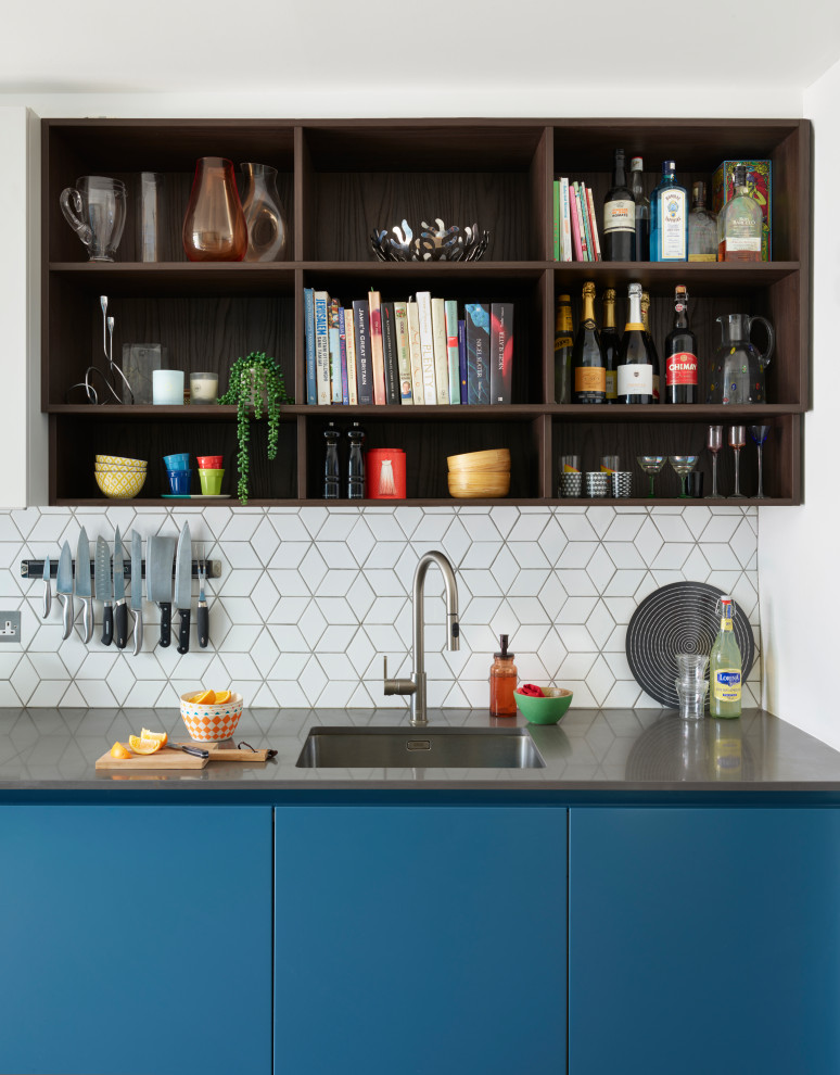 Esempio di una cucina minimal con lavello sottopiano, ante lisce, ante blu, paraspruzzi bianco e top grigio