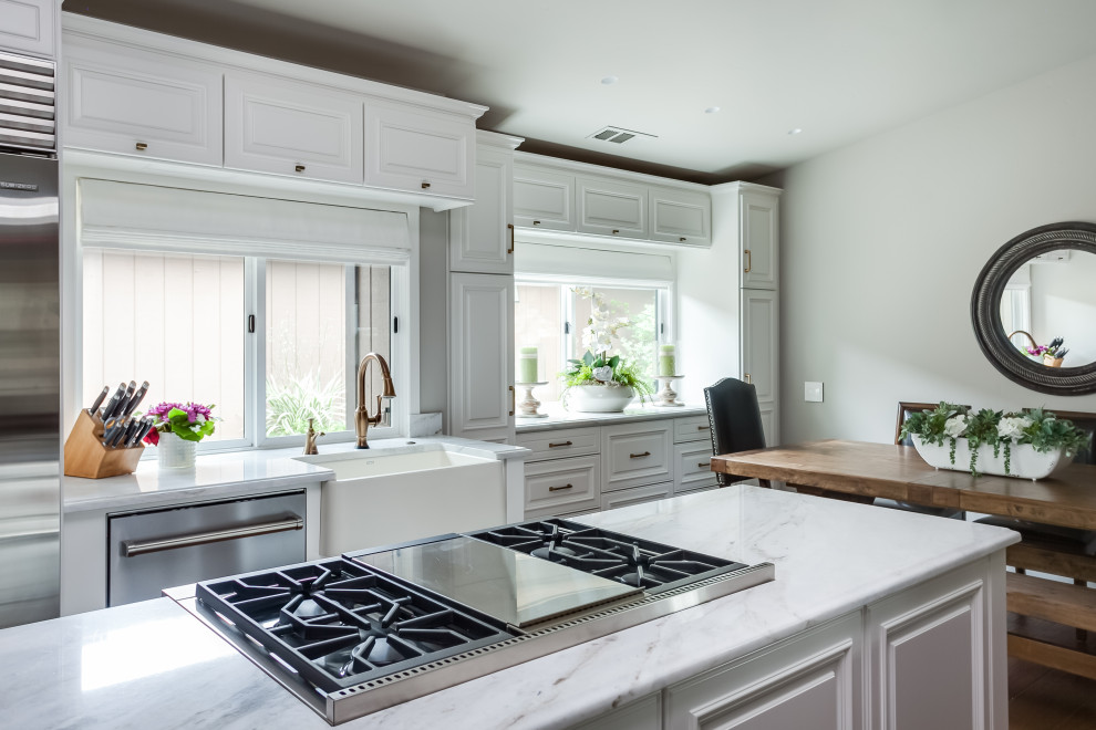 Idéer för ett litet klassiskt grå linjärt kök med öppen planlösning, med en rustik diskho, luckor med upphöjd panel, vita skåp, marmorbänkskiva, rostfria vitvaror, mörkt trägolv, en köksö och brunt golv