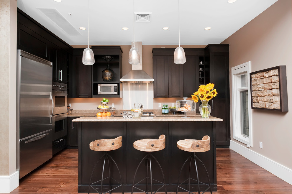 Foto di una cucina classica con ante in stile shaker, ante nere, elettrodomestici in acciaio inossidabile e pavimento in legno massello medio