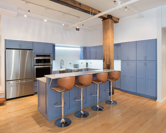 Inredning av ett modernt mellanstort kök, med en rustik diskho, skåp i shakerstil, blå skåp, granitbänkskiva, vitt stänkskydd, stänkskydd i tunnelbanekakel, rostfria vitvaror, mellanmörkt trägolv och en köksö