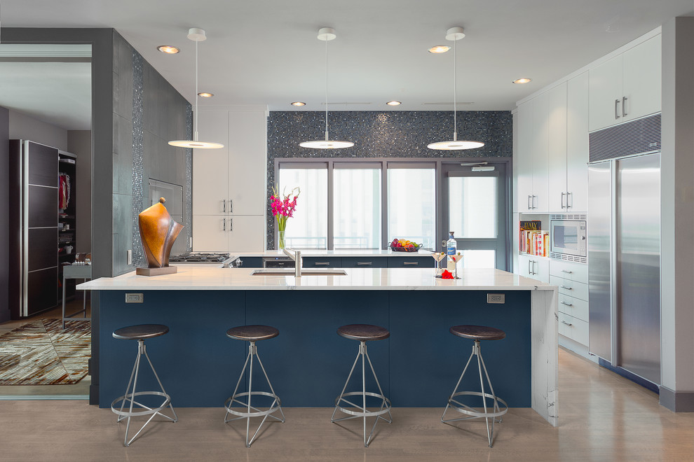 Imagen de cocinas en U actual, pequeño, sin isla, con fregadero bajoencimera, armarios con paneles lisos, puertas de armario azules, salpicadero azul, salpicadero con mosaicos de azulejos, electrodomésticos de acero inoxidable y suelo de madera clara