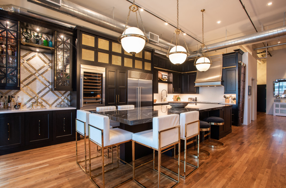 Photo of a medium sized industrial open plan kitchen in Denver with black cabinets, white splashback, stainless steel appliances, an island and black worktops.