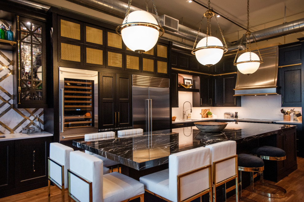 Offene, Mittelgroße Industrial Küche mit schwarzen Schränken, Küchenrückwand in Weiß, Küchengeräten aus Edelstahl, Kücheninsel und schwarzer Arbeitsplatte in Denver